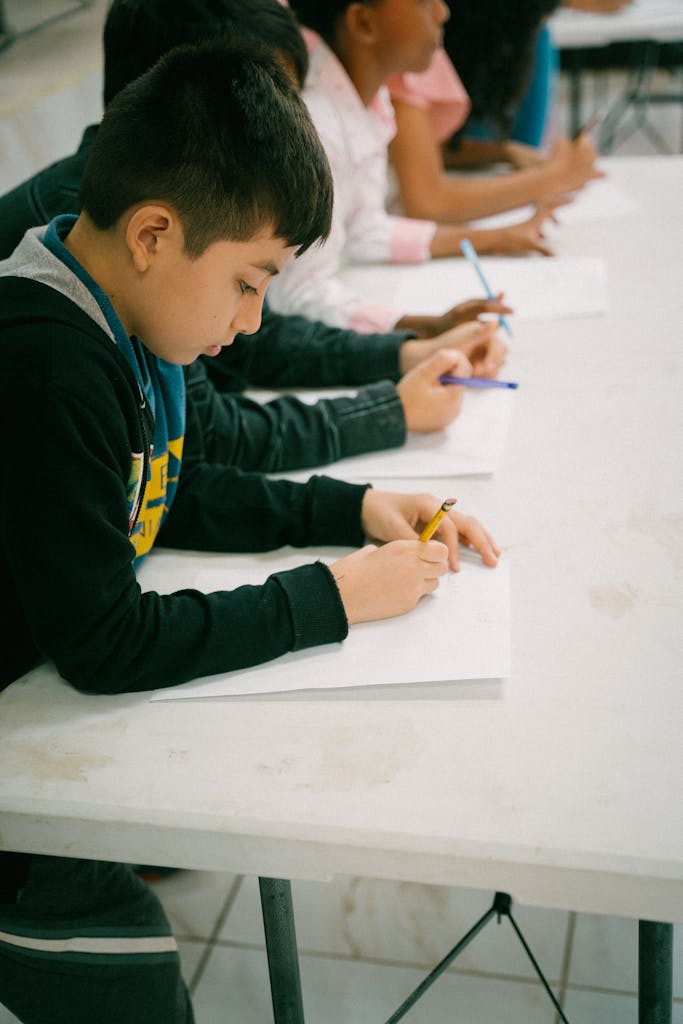 Children writing attentively in a classroom setting, learning and engaging.